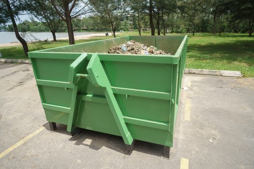 Construction workers disposing of waste into a builders skip